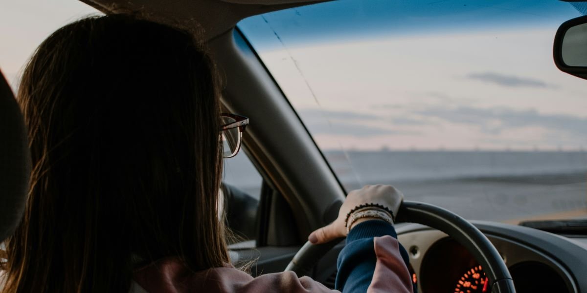 "A woman in a red convertible enjoying a scenic drive at sunset, symbolizing the peace of mind and freedom provided by CarGuard Administration's compliant and transparent vehicle protection plans."